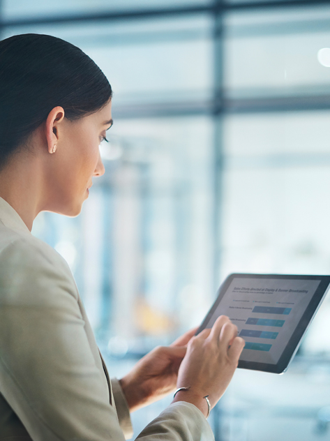 Donna di spalle che utilizza tablet in ufficio.