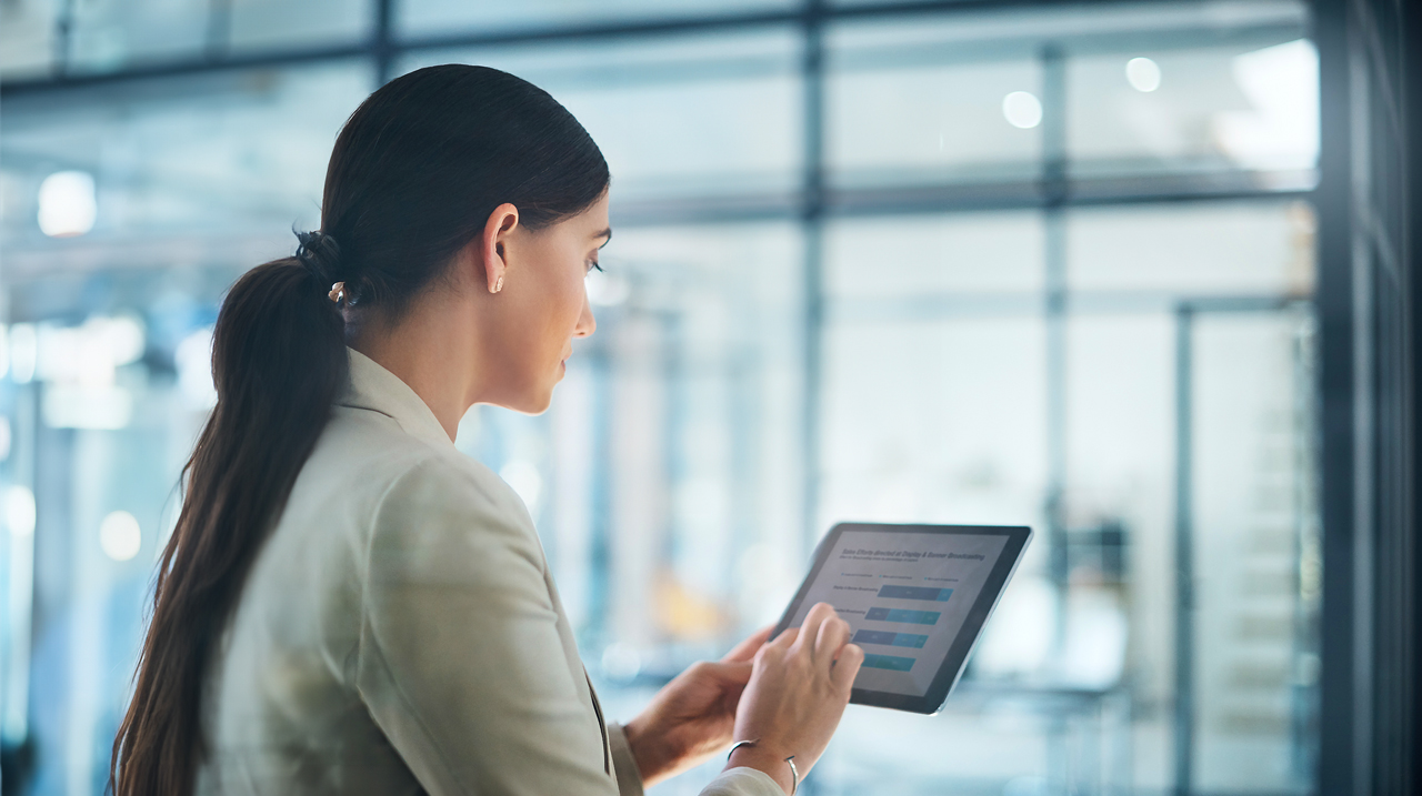 Donna di spalle che utilizza tablet in ufficio.